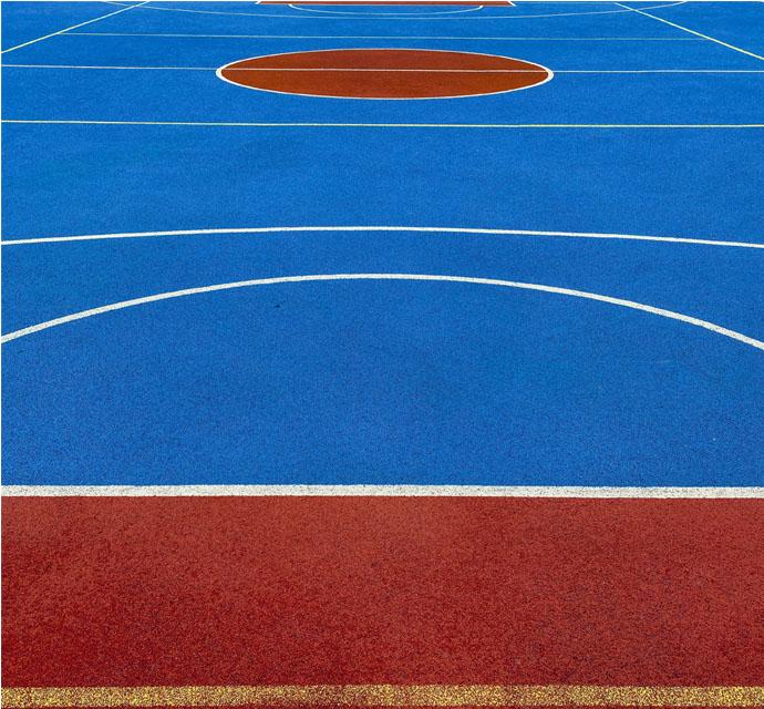 Overhead view of a colorful basketball court with red and blue zones.