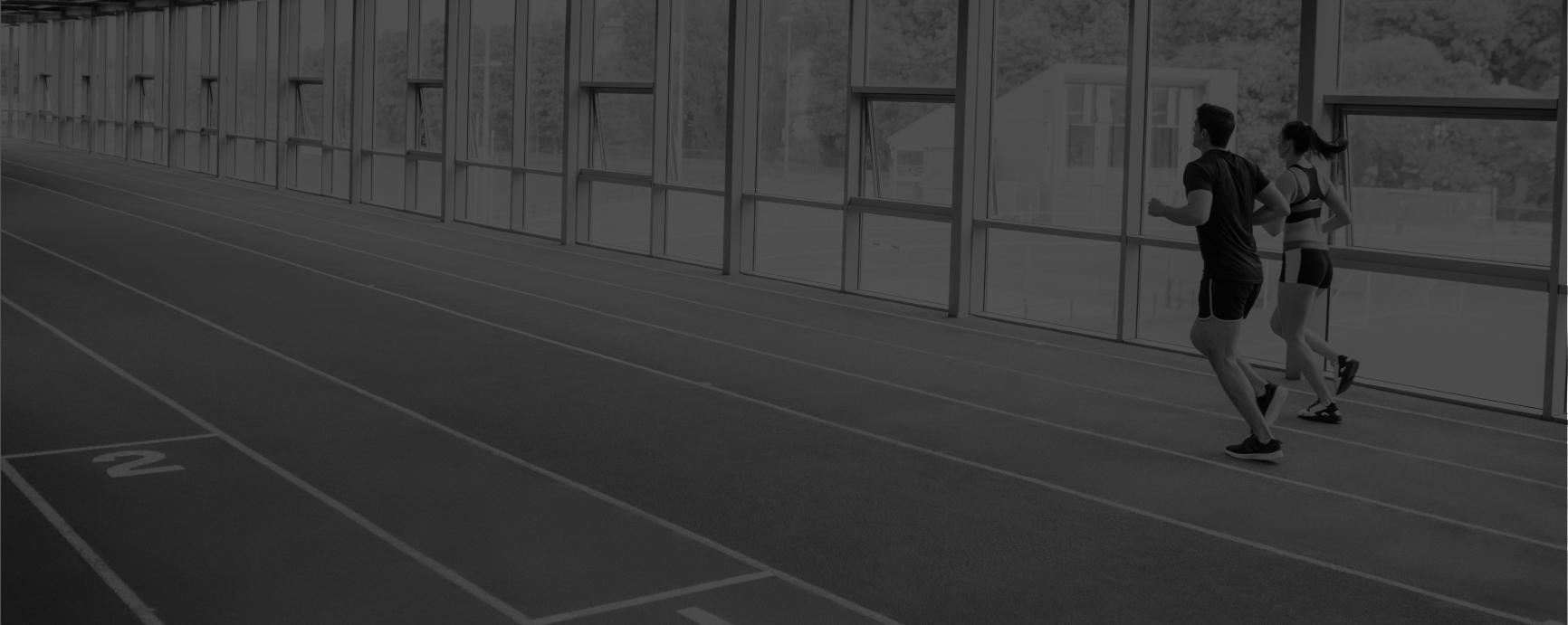 Two runners on an indoor track