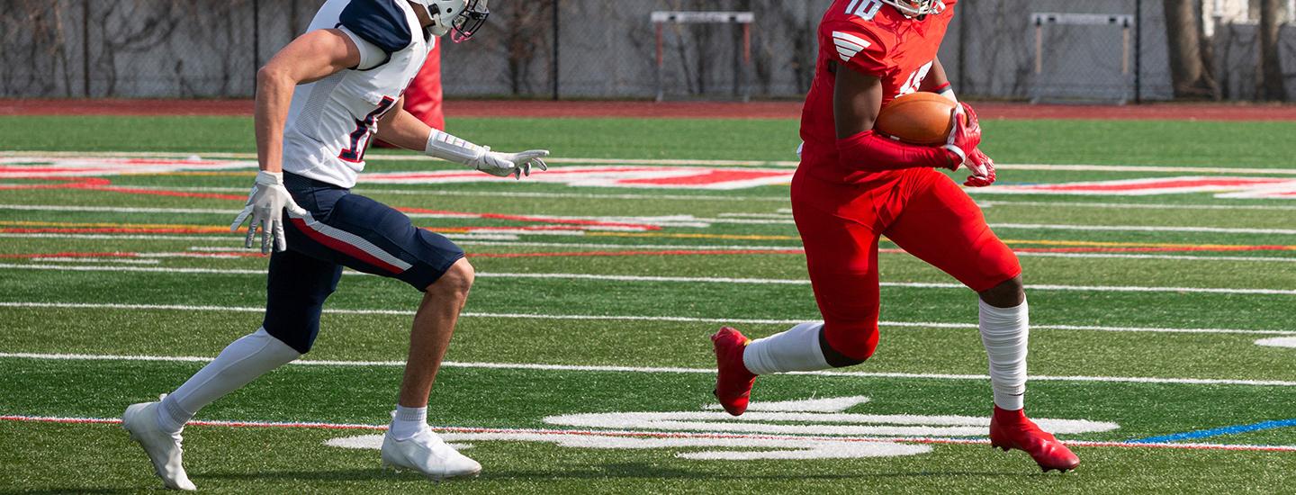 Professional football players in action on a synthetic field during a game.