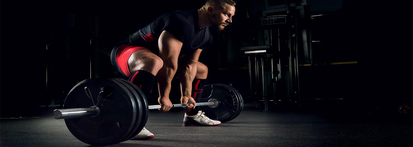 A man that is powerlifting on Ecore Athletic flooring