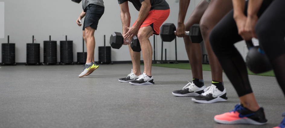 Group of adults performing dumbbell exercises in a fitness class.