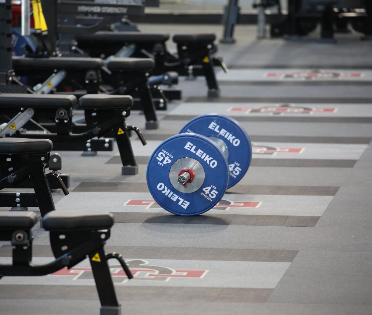 A barbell and weights on a weight floor platform floor