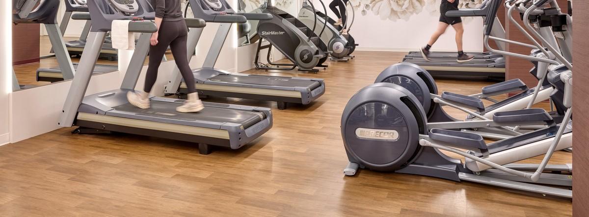 Cardio equipment in a gym over Balanced Motivate Class I flooring