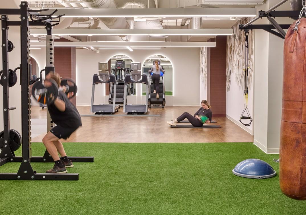 A fitness center with RageTurf in Green installed and a man working out on the turf
