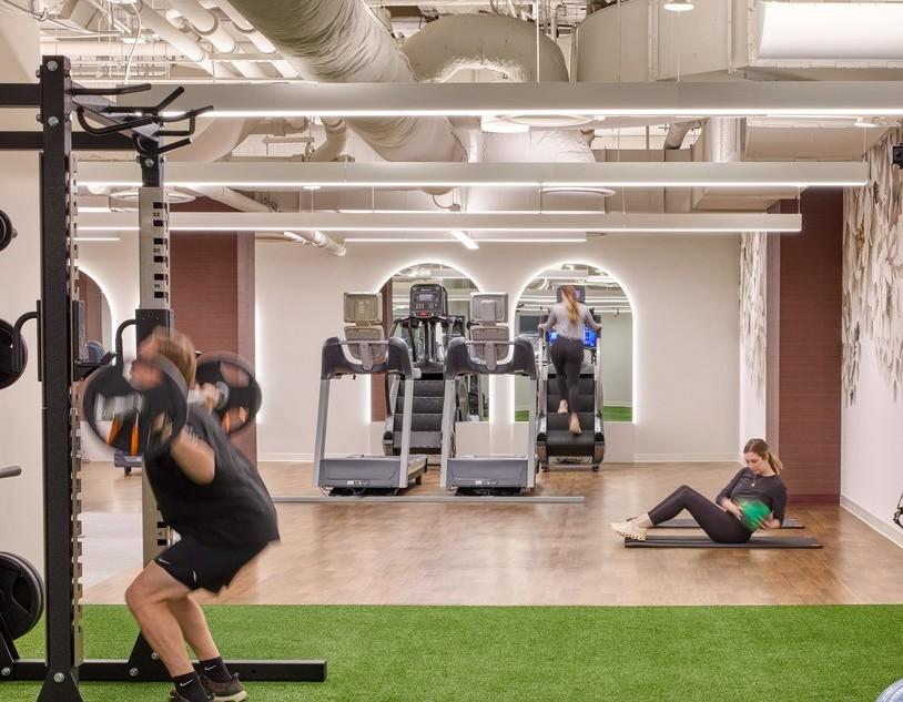 Woman and man working out in fitness center with Balanced Motivate installed