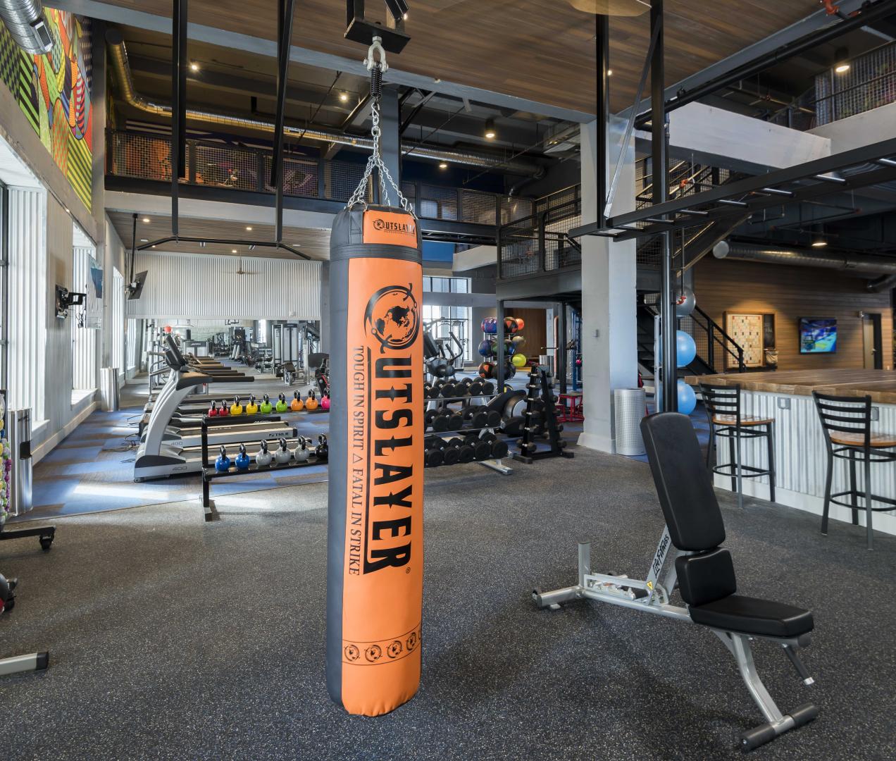 a fitness center or gym with a bench press and a punching bag