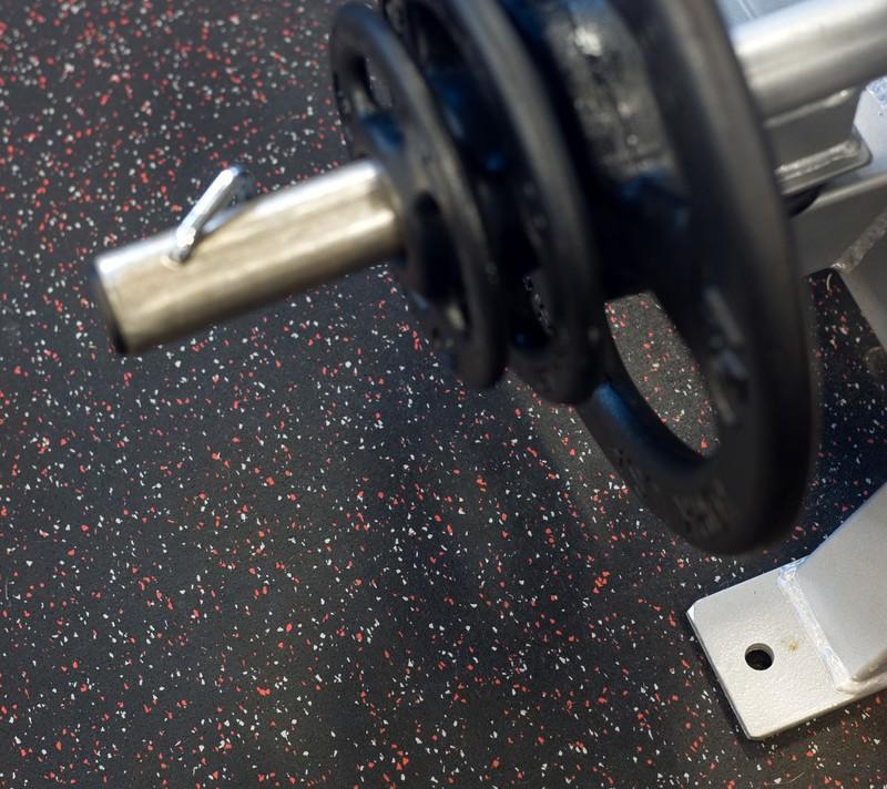 A top down shot of a bench press machine with the flooring visible