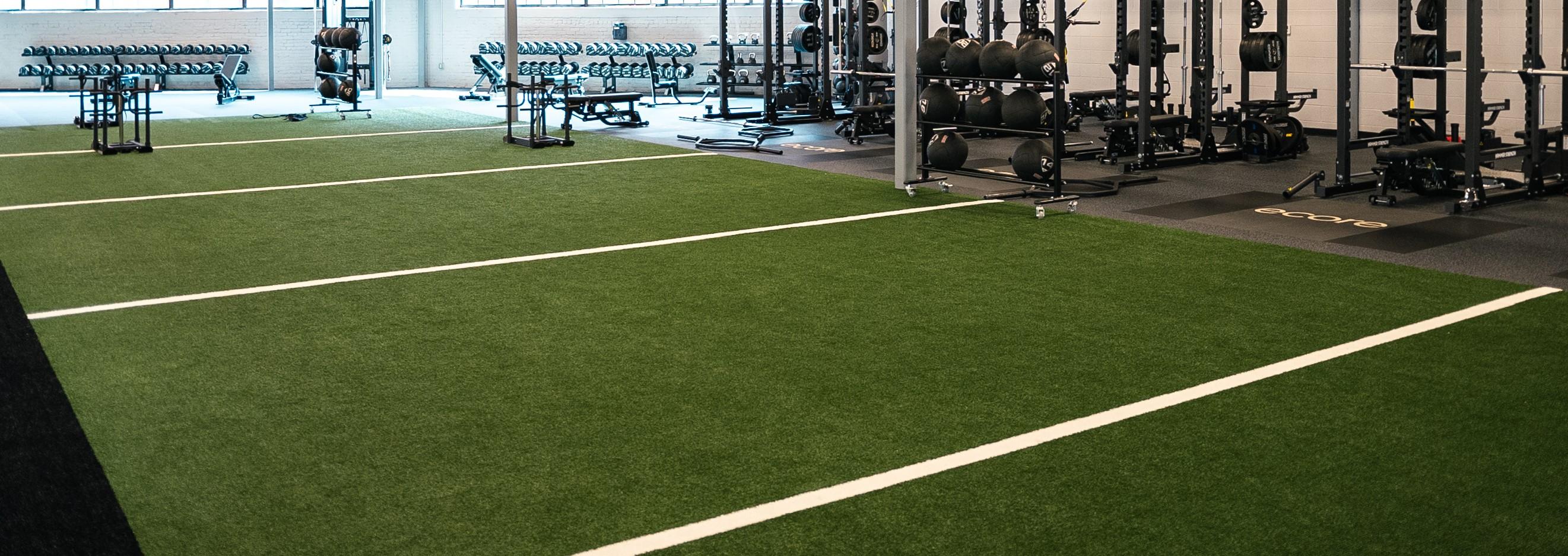 A gym with a section of turf installed with white lines