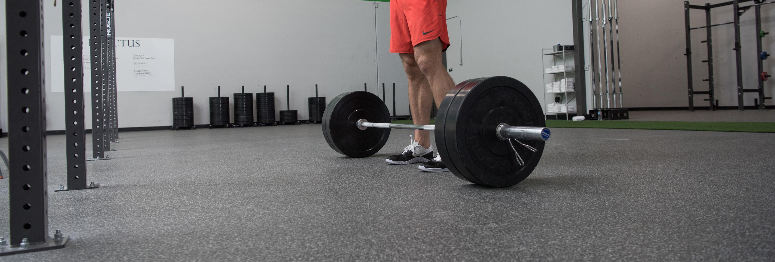 Man looking down at barbell getting ready for a deadlift