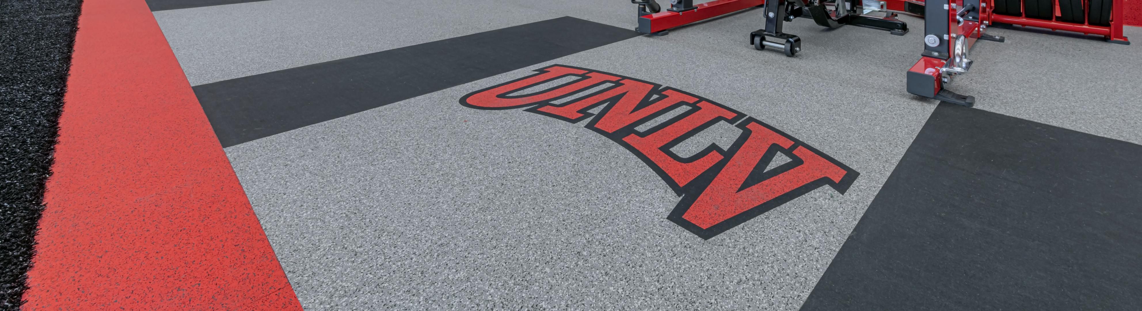 An overhead shot of a lifting platform with the UNLVA Logo in the floors