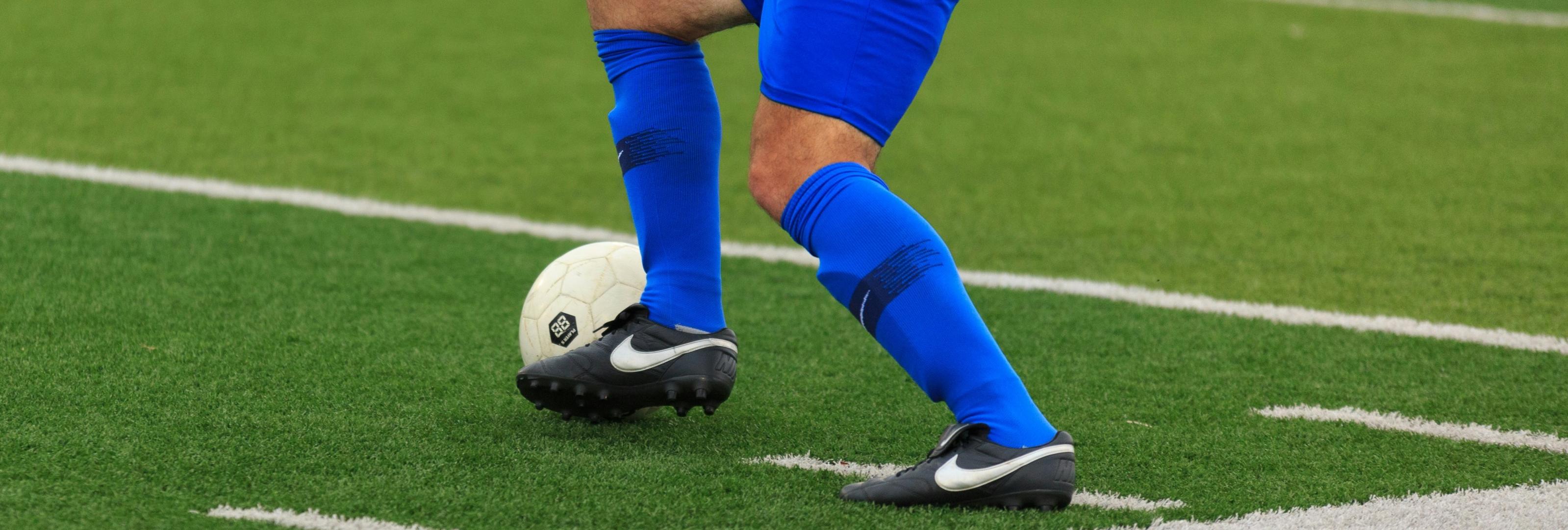 A soccer player dribbling a soccer ball on a FierceTurf Monster soccer field