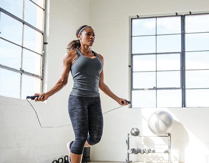Woman jumping rope in a fitness facility.