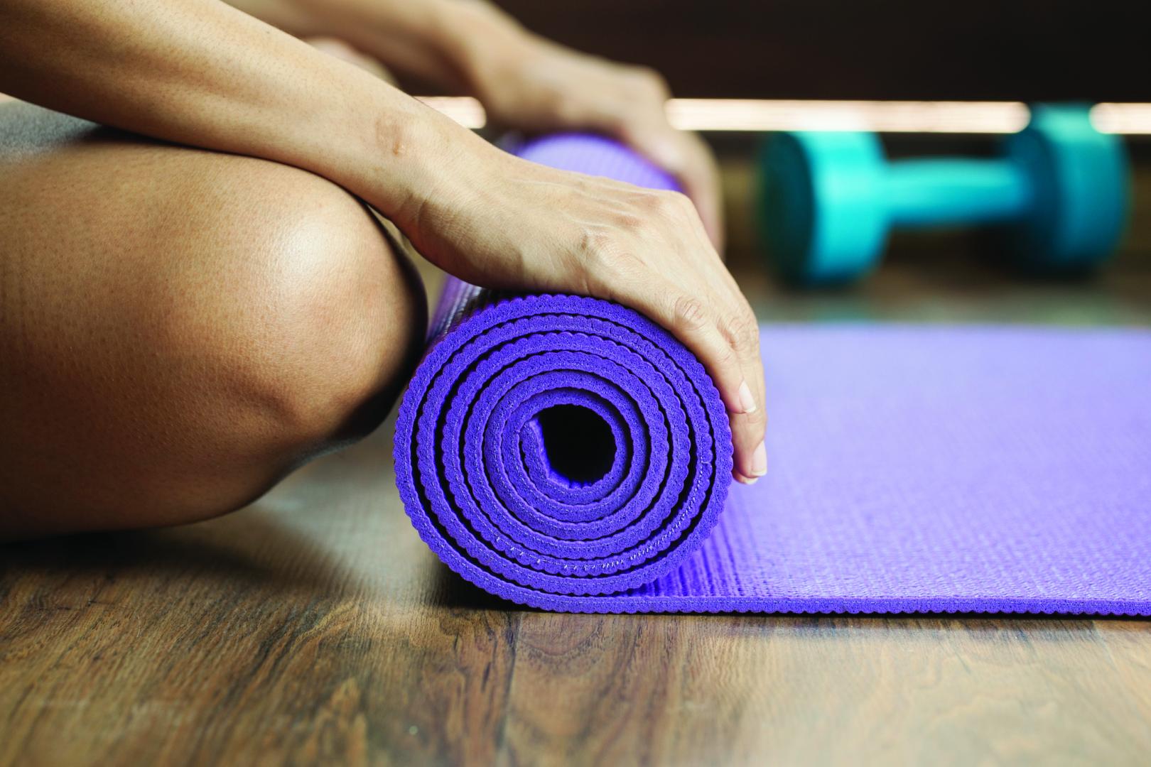 Someone rolling up a Yoga Mat