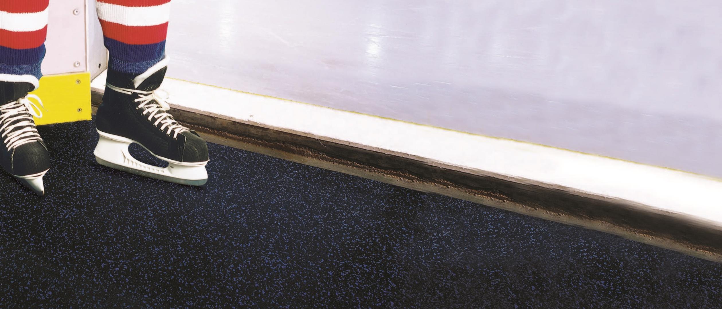 a hockey player standing outside of an ice rink on Blade flooring