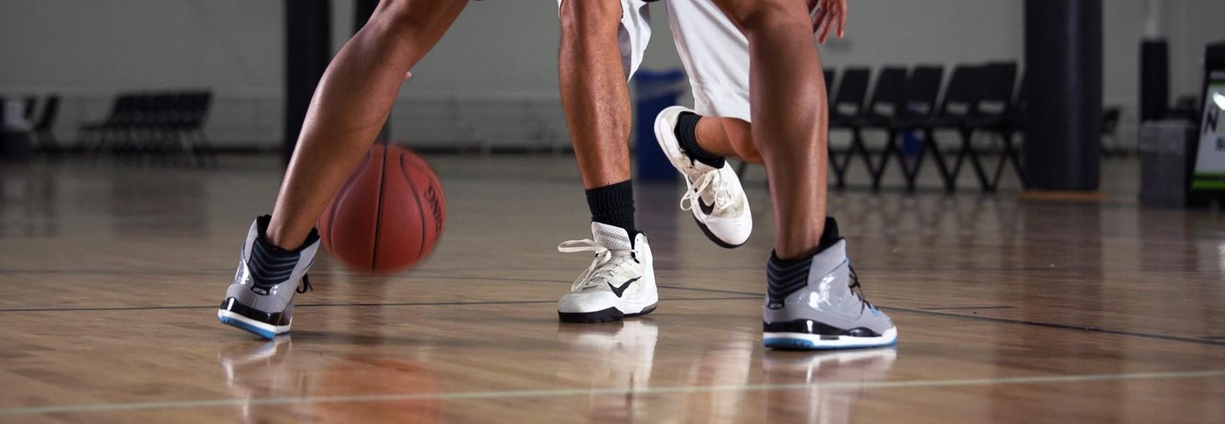 Two men playing basketball on a baller motivate court