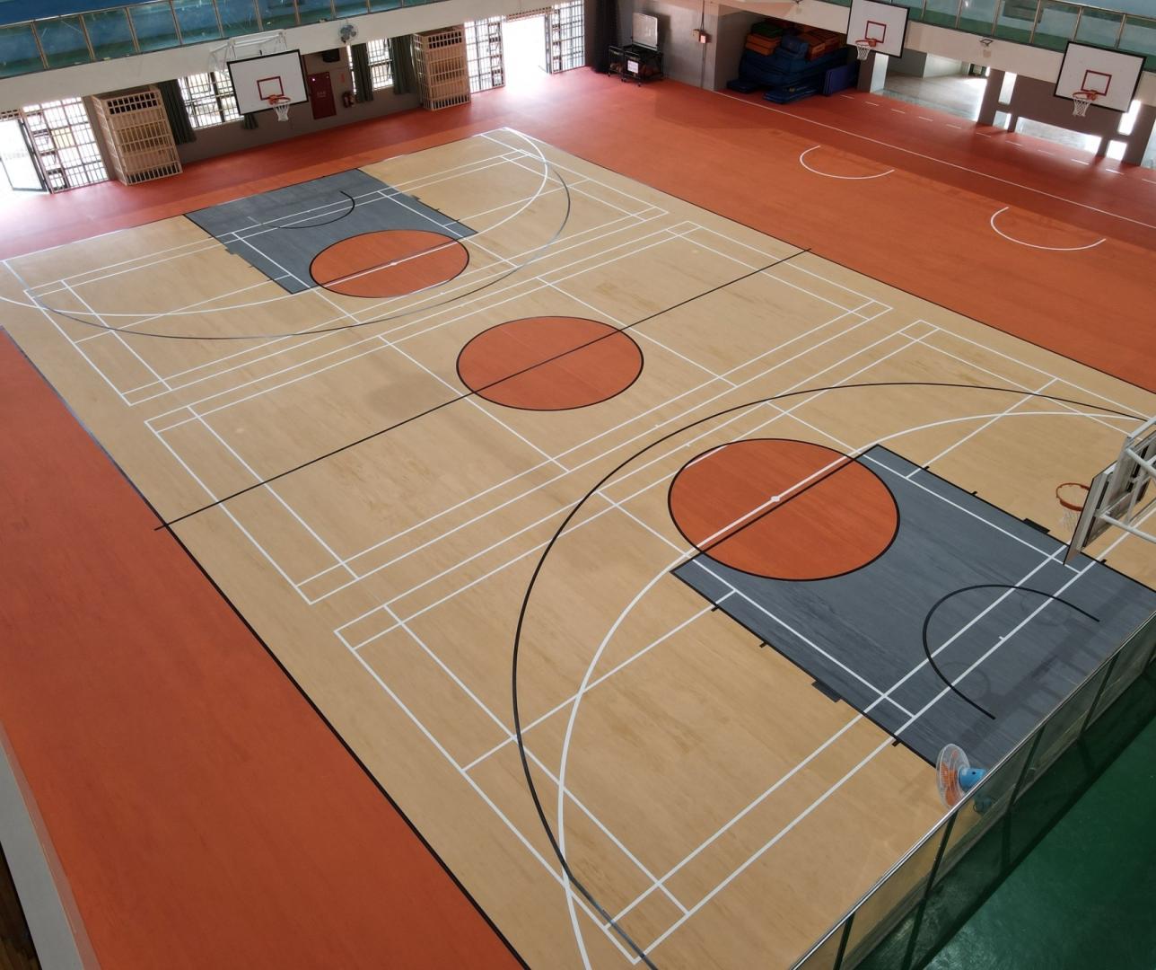 Overhead view of a colorful basketball court with orange and blue zones.