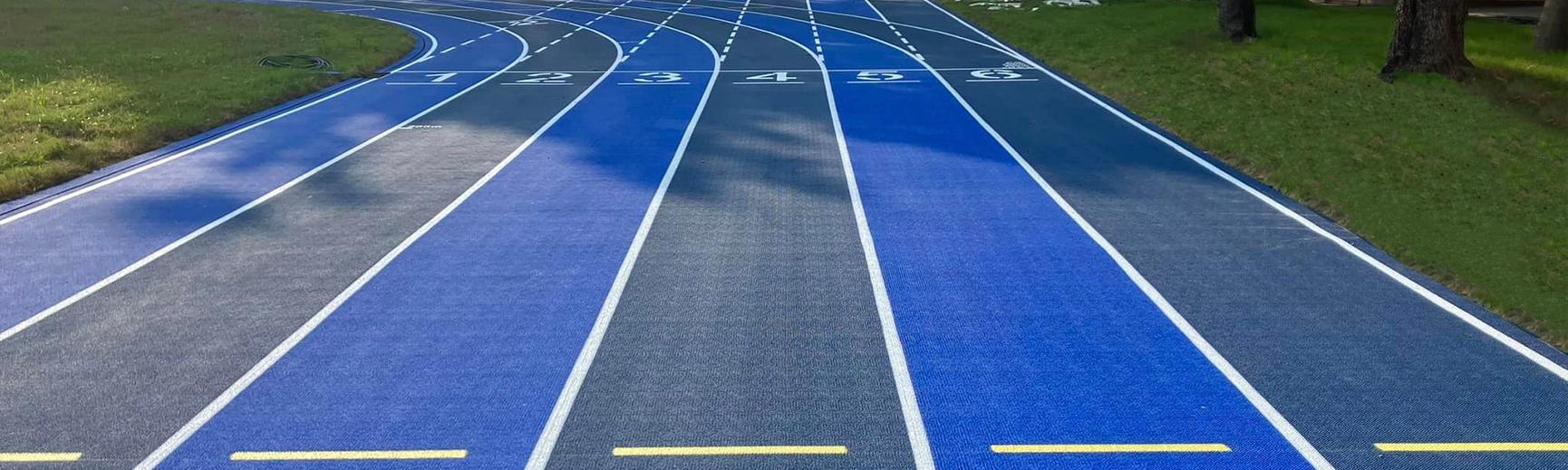 Outdoor running track with numbered lanes and blue surfacing.