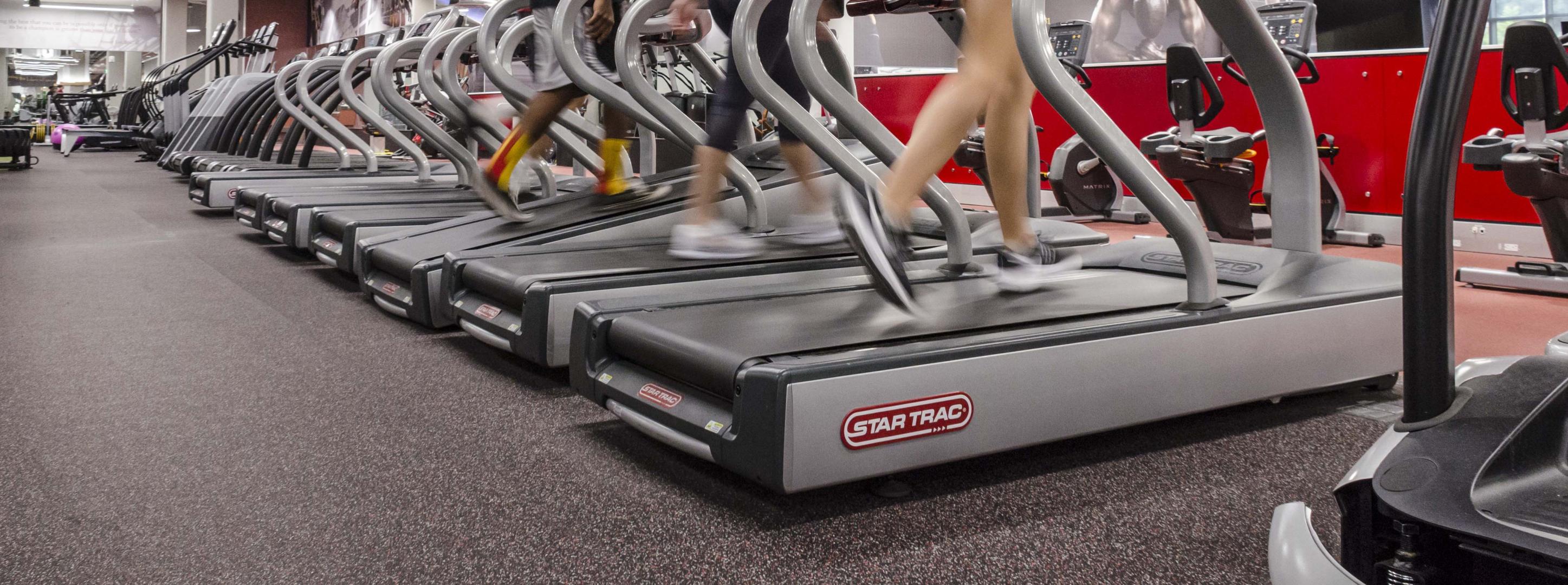 A group of people running on treadmills and causing noise