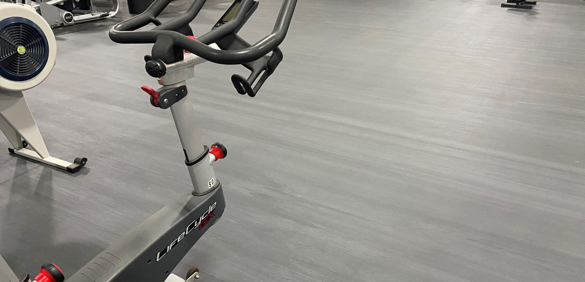 Variety of exercise equipment on a calendered rubber gym flooring.