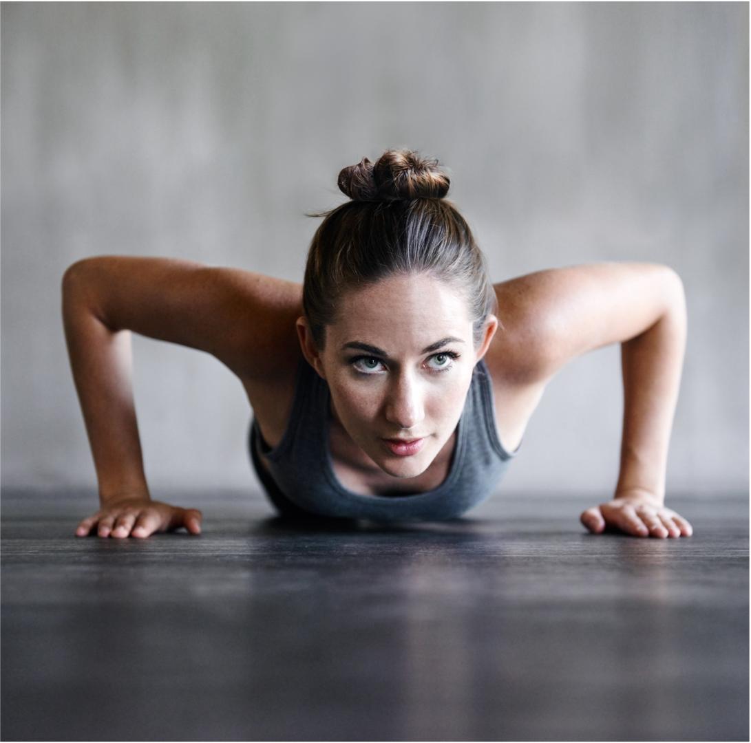 A woman doing a push up on a ComPact-Marble flooring.