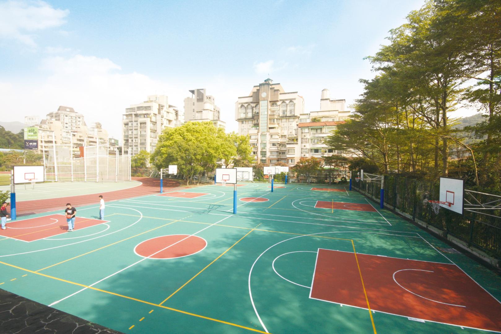 A colorful outdoor court with people playing basketball