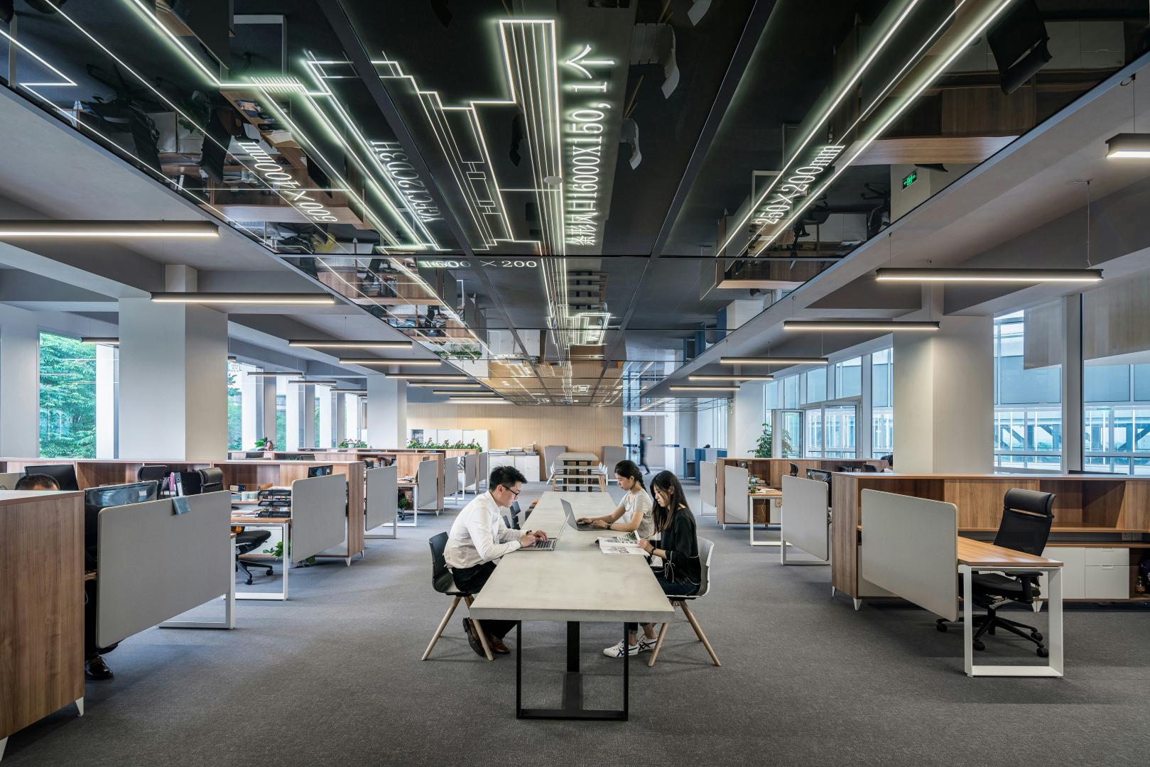a group of people doing work in an open office space