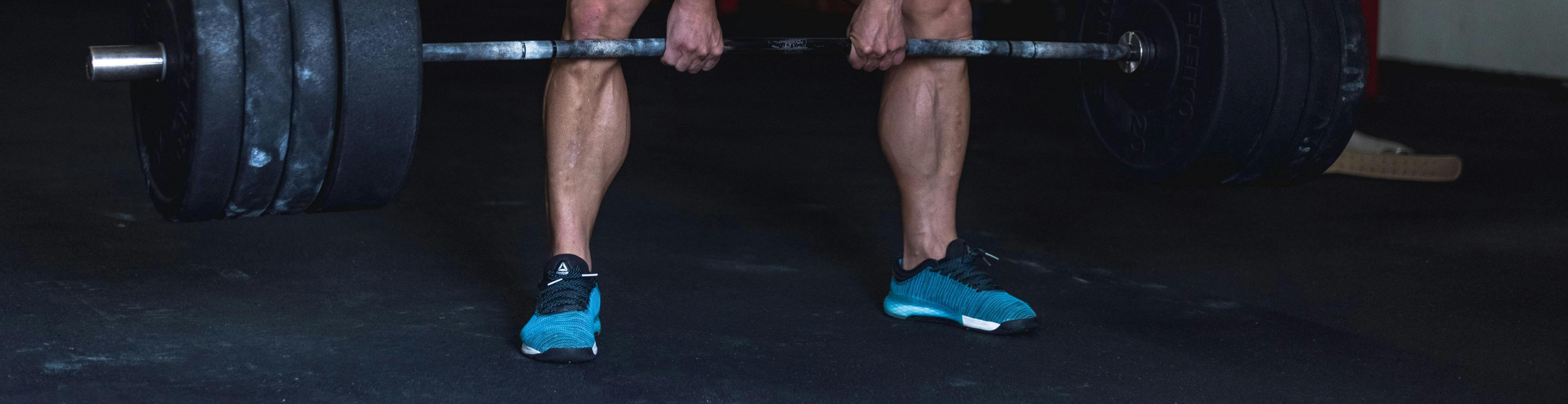 A shot of a man in a gym doing a deadlift with heavy weights