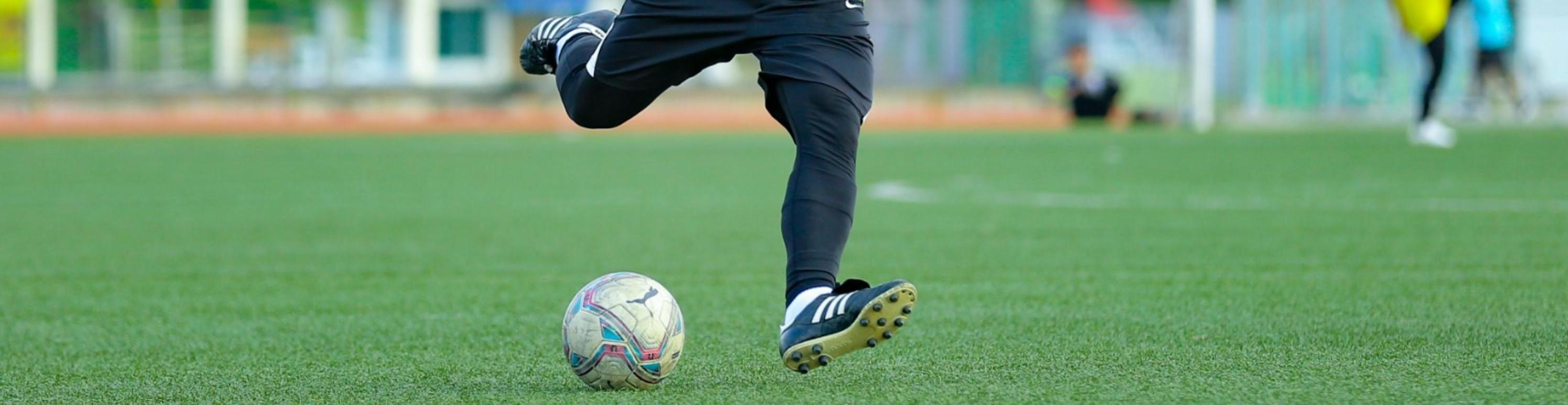 A soccer player dribbling a soccer ball on a FierceTurf Monster soccer field