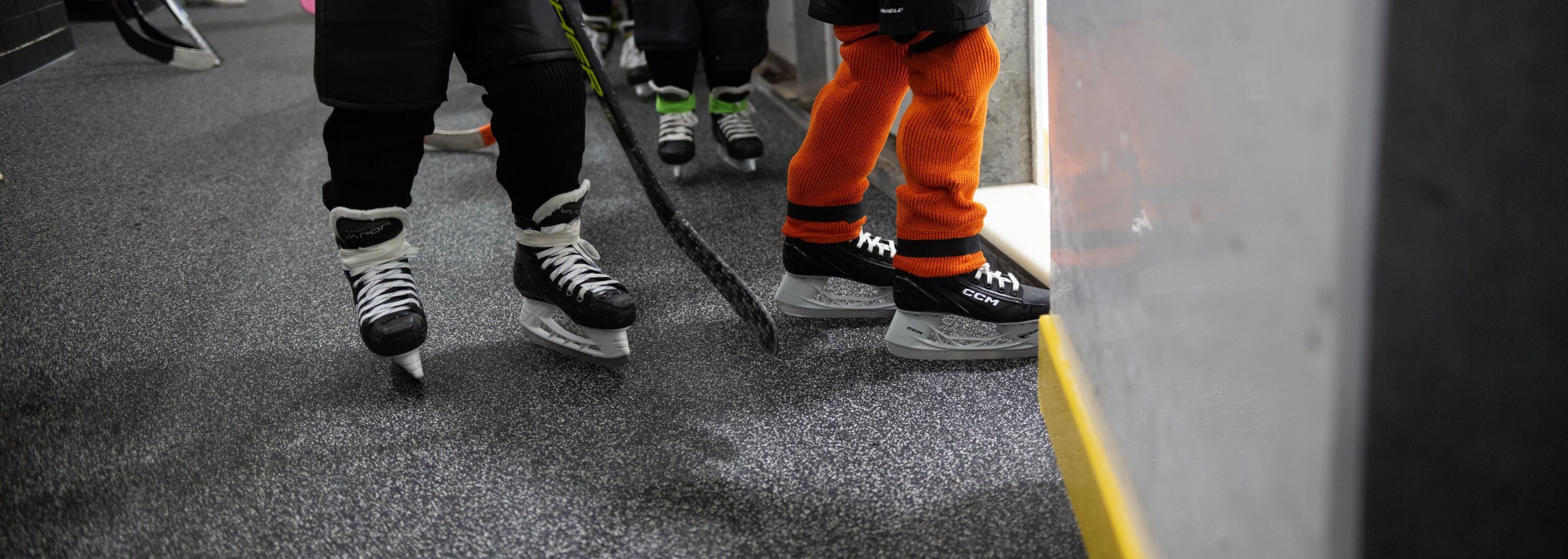 a hockey player standing outside of an ice rink on Blade flooring