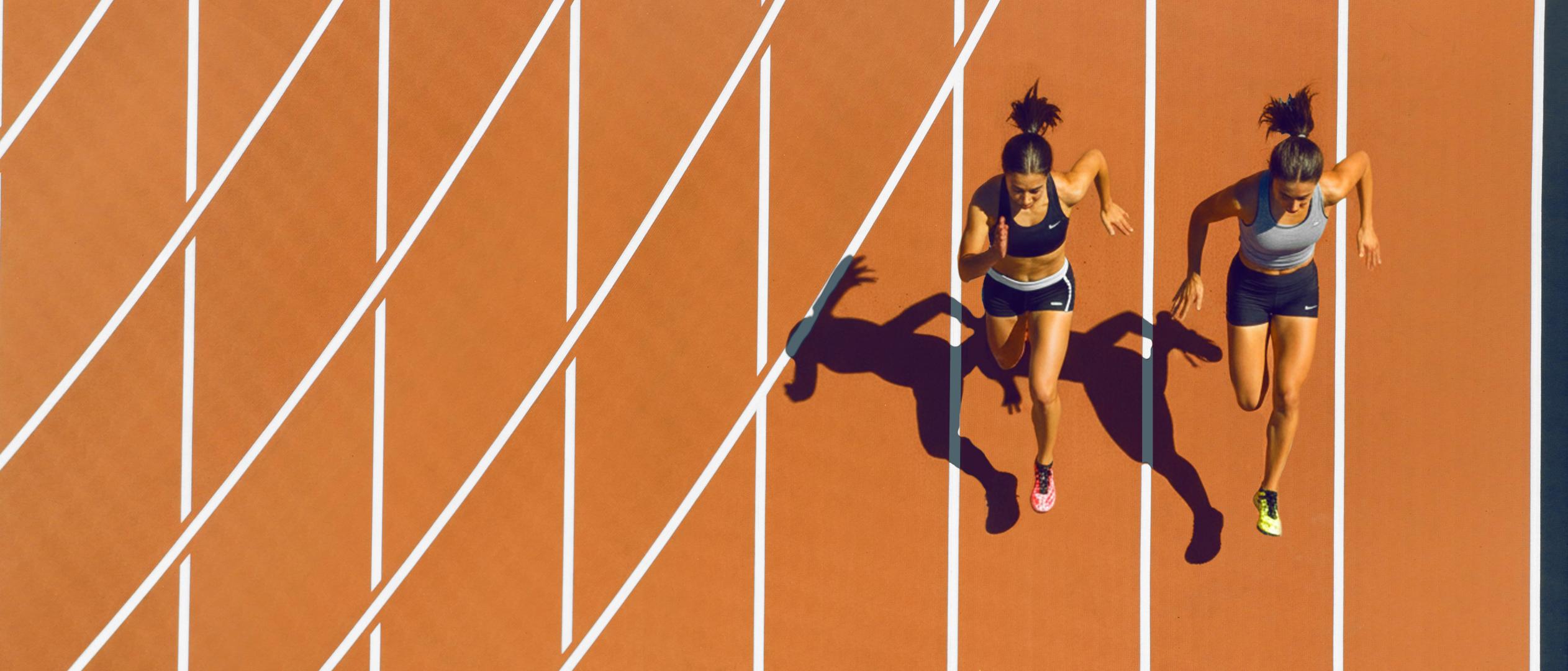 Two women athletes running on a track