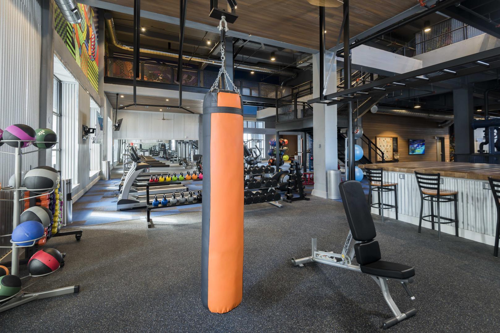 a fitness center or gym with a bench press and a punching bag