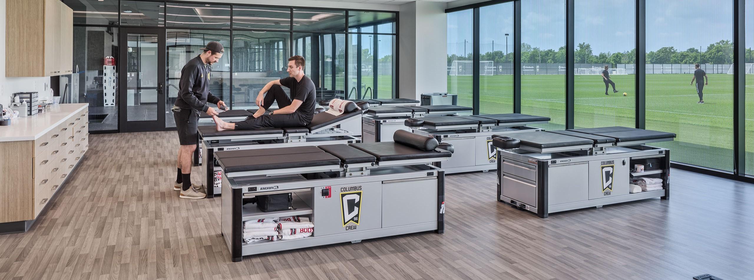 A shot of an athlete getting looked at by a professional in a therapy & rehab setting