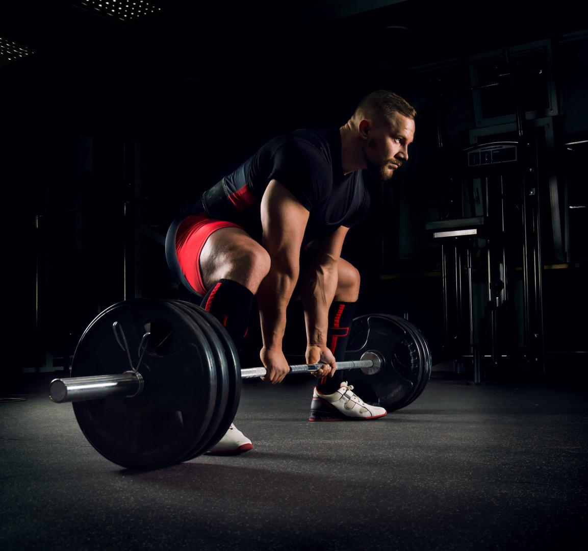 A man in a deadlift position working out on a Performance Beast Plus floor