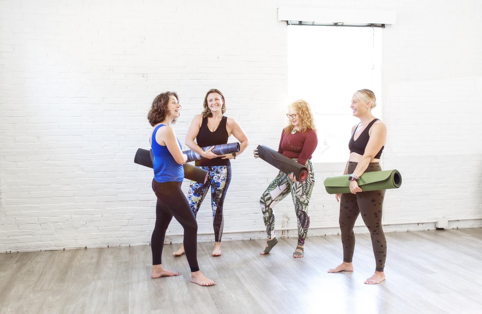 A group of people doing yoga in the warrior pose in a yoga studio