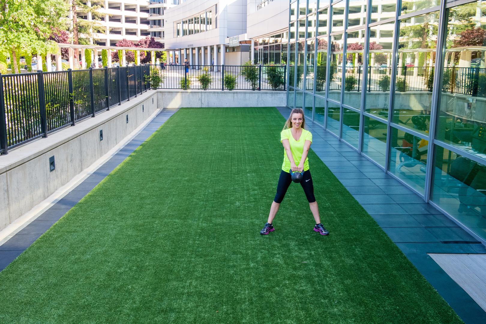 A woman exercising on an outdoor turf area