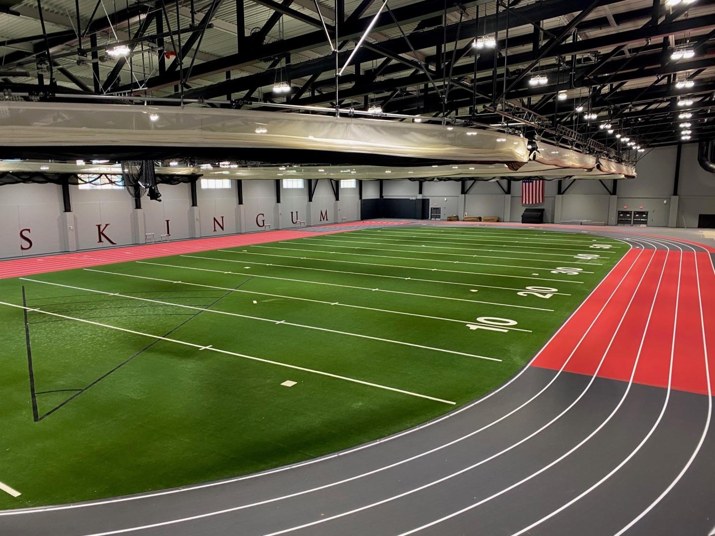 Overhead view of an indoor sports complex featuring a field and running track.