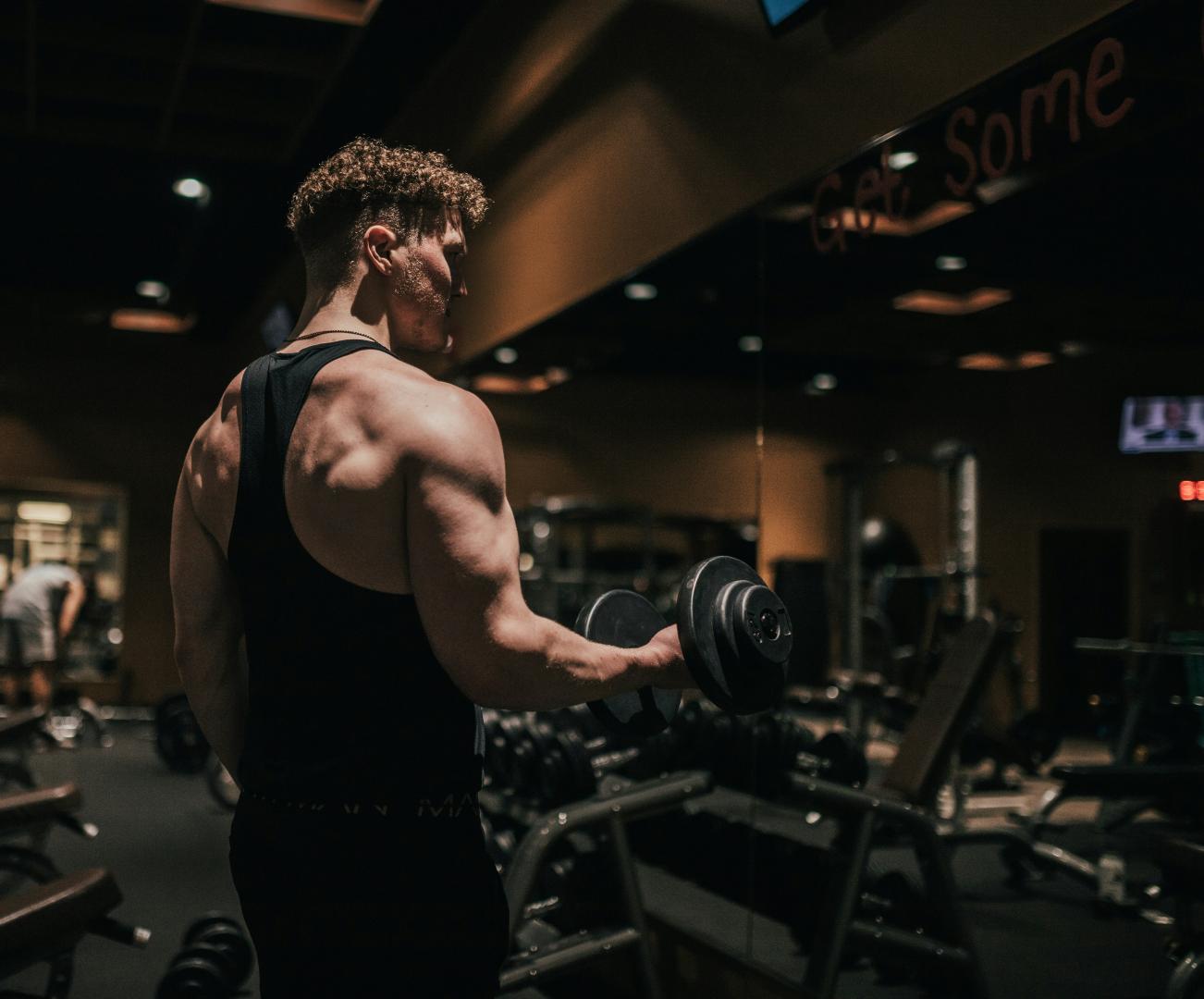 A man lifting free weights in a gym
