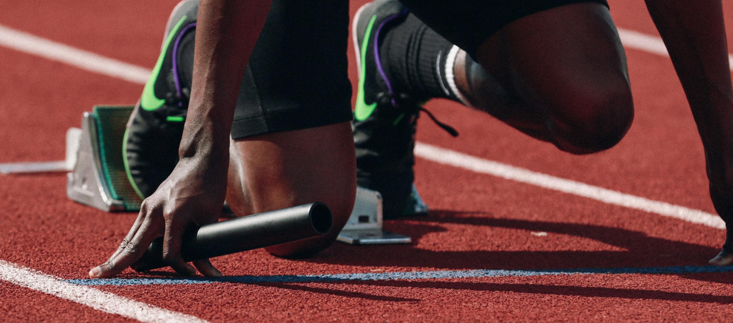 A man lining up at the start for a race on a track