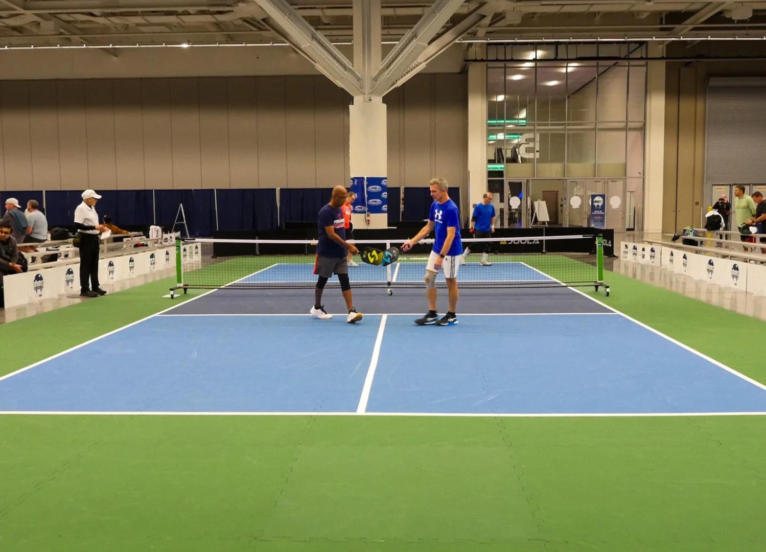 Two players on a pickball court