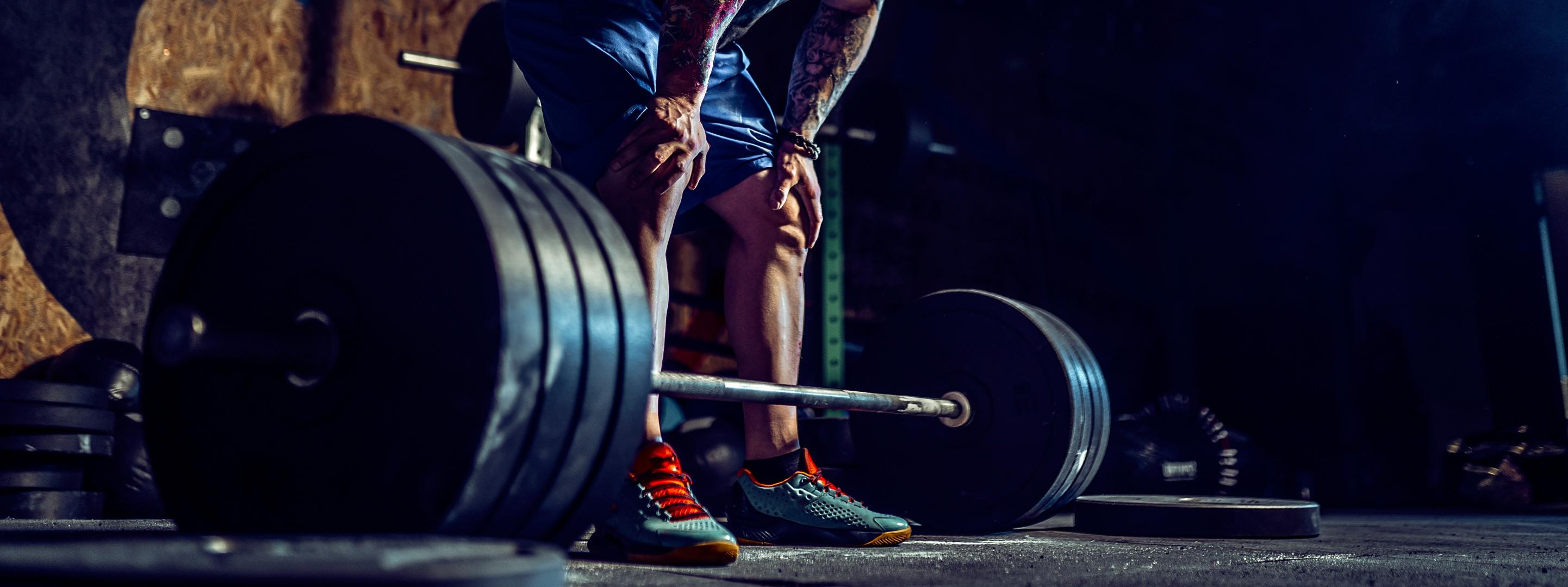 A man leaning over a barbell